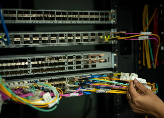 Technicien réalisant une dépannage dans une baie de brassage informatique